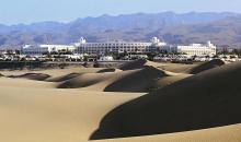Blick über Sanddünen auf die Hotelanlage