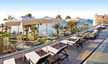 Terrasse mit Liegestühlen und Blick auf den Garten und das Meer