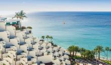 Blick über Hotelanlage auf Palmen und Meer