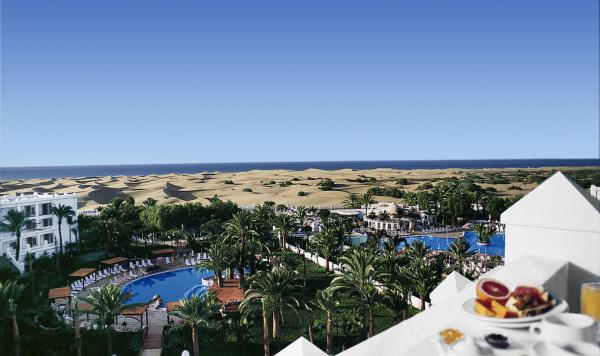 Blick über das Hotelgebäude auf den Pool und den Strand