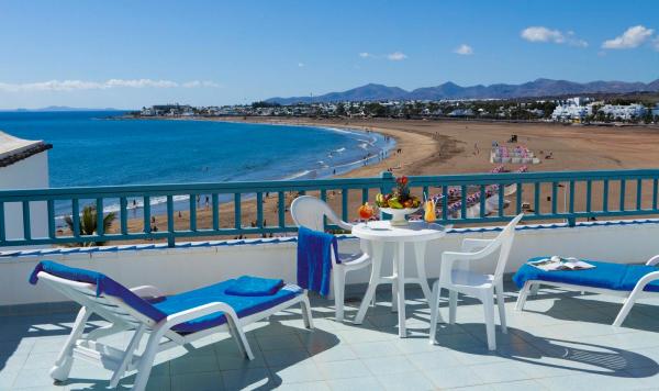 Blick von terasse mit Liegestühlen und Blick auf den Strand