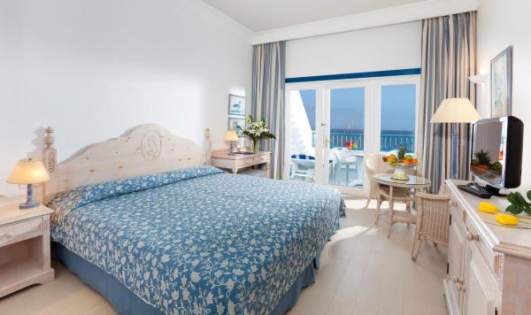 Wohnbeispiel mit Bett, kleiner Sitzgruppe und Balkon