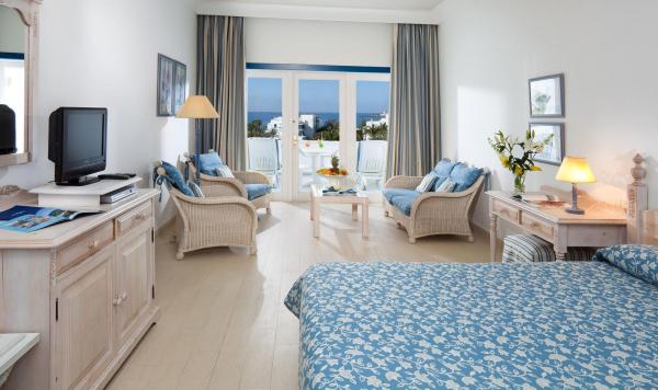 Wohnbeispiel mit Sitzecke, TV und Blick auf den Balkon