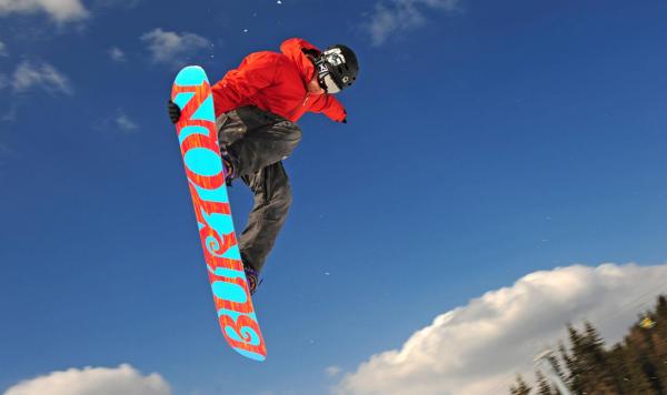 Snowdoarder, der einen Sprung vollführt