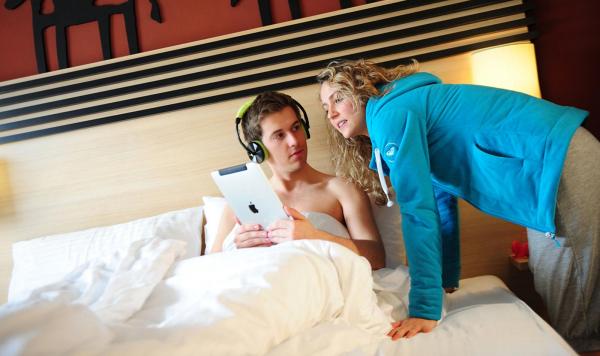 Gäste auf Hotelzimmer mit iPad