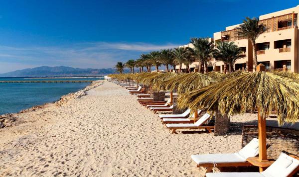 Strand mit Liegen und Sonnenschirmen