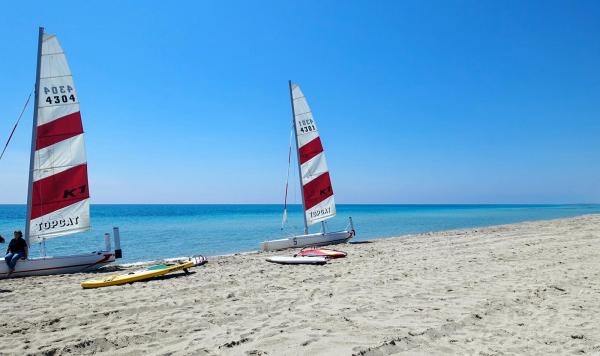 Strand mit kleinen weiß-roten Segelbooten