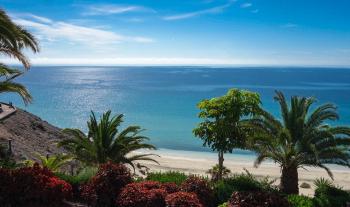 Blick über den Hotelgarten auf den Strand und das Meer