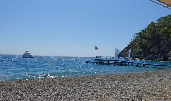 Strand mit Kieseln und türkisem Wasser
