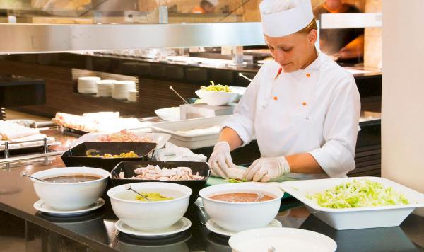 Köchin bereitet frische Speisen zu