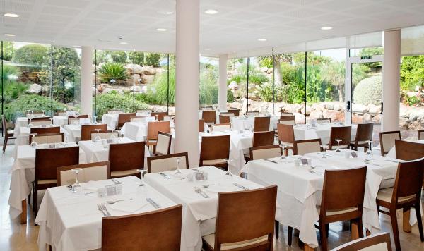 Eingedeckte Tische im Speisesaal mit Blick auf den Garten