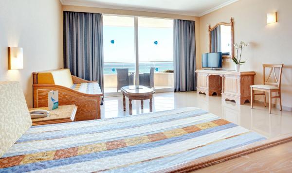 Wohnbeispiel mit Bett, Sitzecke und Balkon mit Meerblick