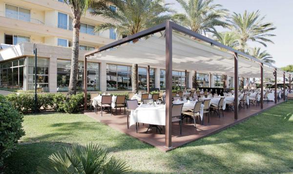 Hotelgebäude mit überdachtem Sitzbereich im Garten