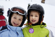 Zwei Kinder mit Wintersport Ausrüstung